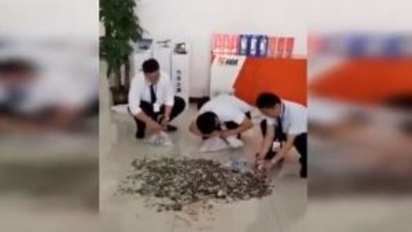 Cina, 66 borse di monetine per comprare l'auto - VIDEO