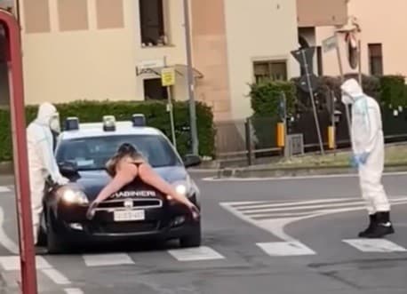 Coronavirus, ragazza nuda sul cofano dell'auto dei Carabinieri VIDEO