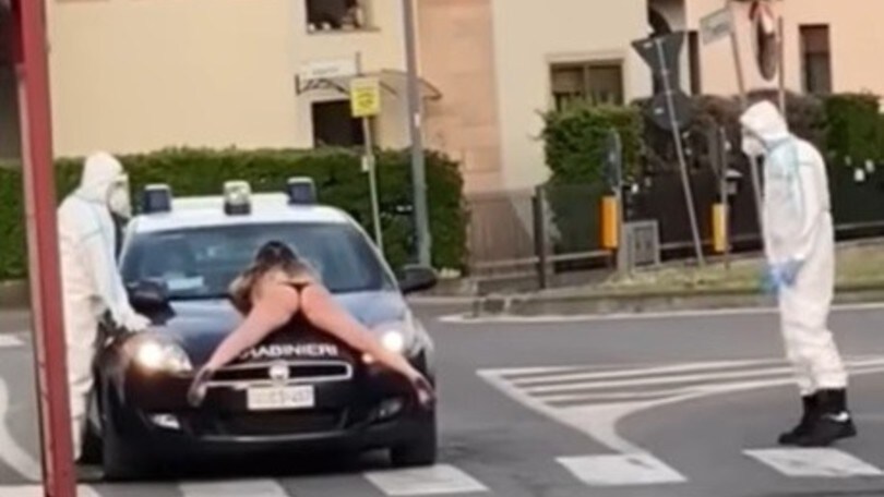 Coronavirus, ragazza nuda sul cofano dell'auto dei Carabinieri VIDEO