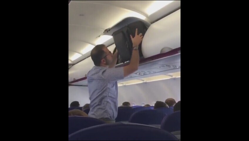 Prova a sistemare il suo bagaglio nell’aereo ma mette tutti in imbarazzo