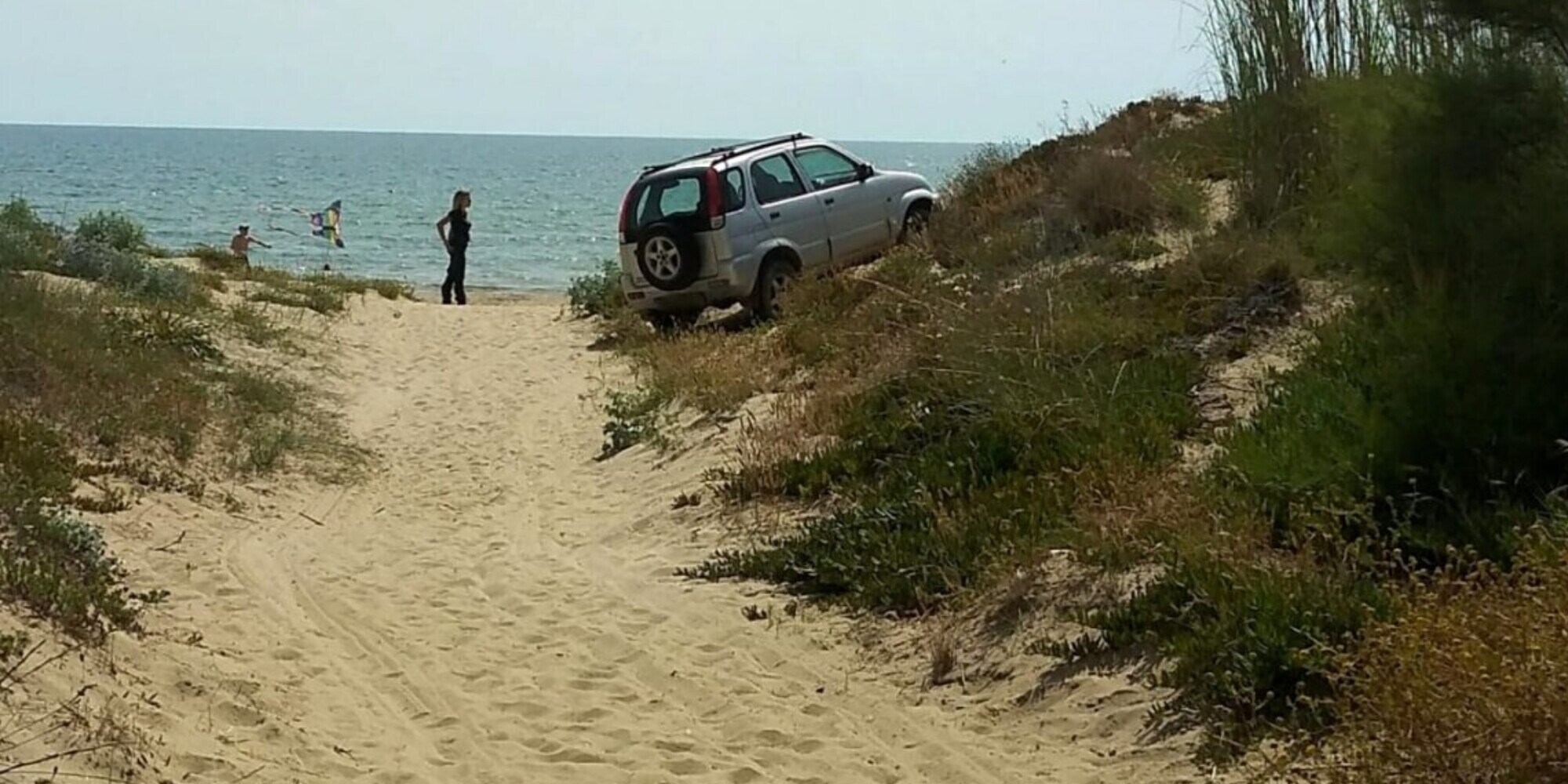Parcheggia l'auto in spiaggia e si sdraia a prendere il sole