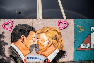 La street art di Berlino non risparmia Trump e Xi Jinping: il bacio in mascherina