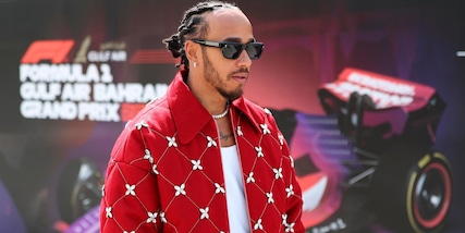 Hamilton, giacca rosso Ferrari e chiacchierata con Leclerc